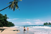 women in bikinis walking on a tropical shore 