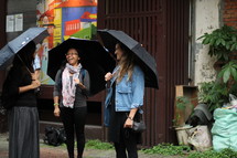 friends chatting holding umbrellas 