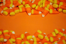 Orange surface with candy corn borders for Halloween or Thanksgiving message.