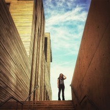 Woman standing at the top of outdoor staircase 