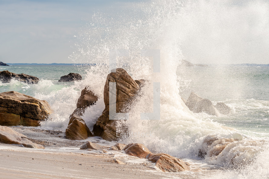 waves crashing into rocks on a shore 