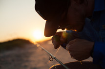 a fisherman adjusting the line on his fishing pole 