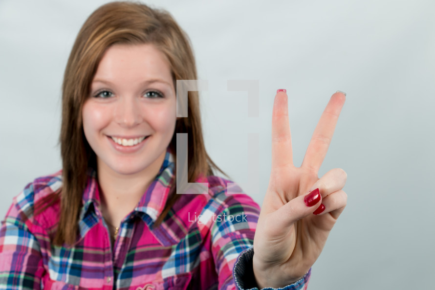 young woman showing a peace sign 