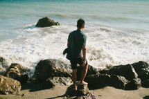 a man walking on a rocky shore 
