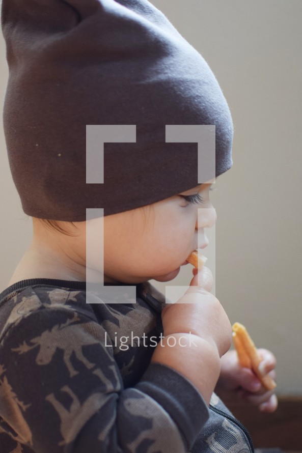 a toddler boy snacking 