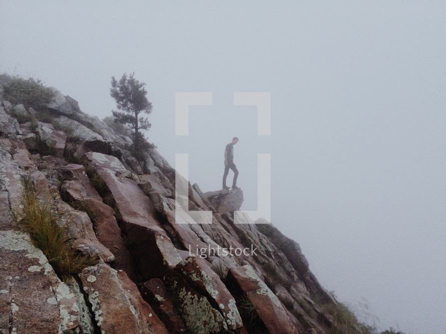 Man standing at the edge of a rocky cliff.