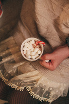 girl holding a mug of hot cocoa and marshmallows 