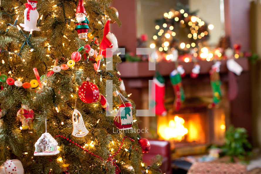 ornaments on a decorated Christmas tree and a hearth 