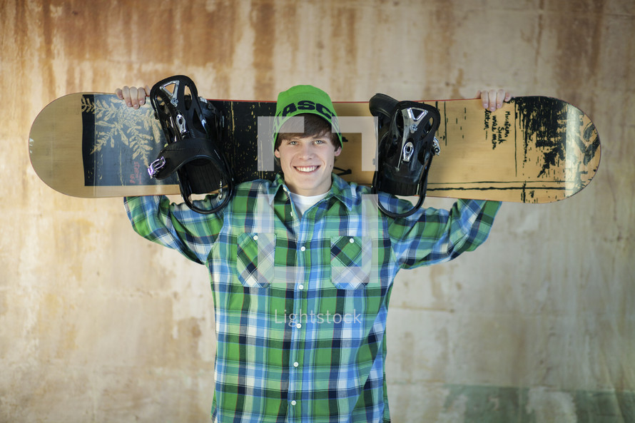 young man holding a snow board 