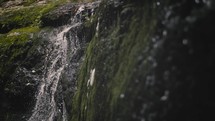 water flowing over mossy rocks 
