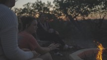 teens sitting around a fire pit 