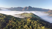 Aerial morning above foggy landscape in autumn with beautiful golden colors. Slow motion flight
