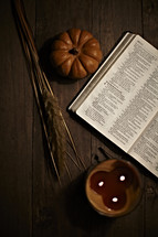 fall scene with bible, candle, and pumpkin