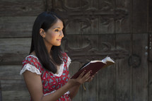 woman standing reading a Bible with her face glowing