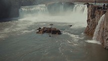 tourists watching a rushing waterfall 