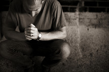 A young man kneels as he prays.