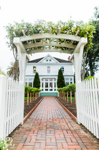 Pathway leading to house brick walkway white victorian home picket fence 