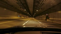 Point of view of a car driving through a tunnel at night