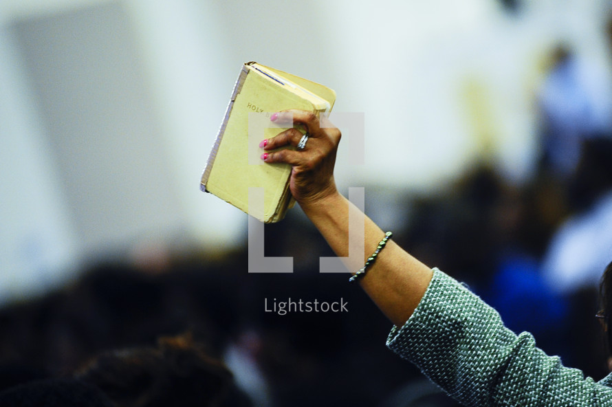 A woman holding up a hymnal 