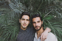 two men hugging and tropical plants 