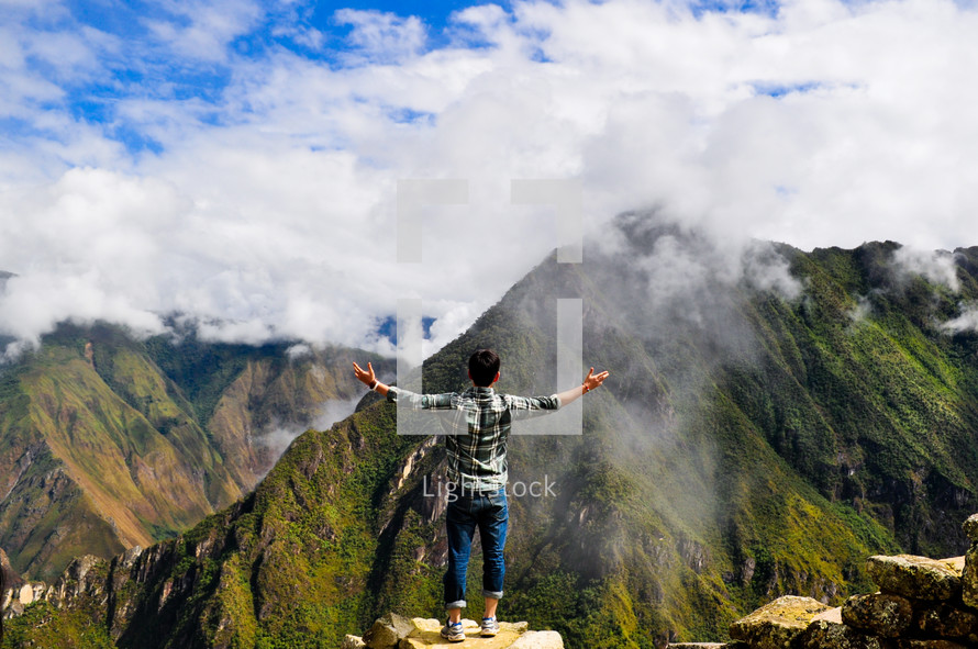 man standing at the top of a mountains 