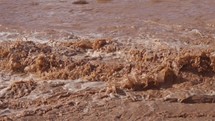 River stream of brown muddy water after rain storm slow motion
