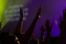 teens with raised hands at a worship service 