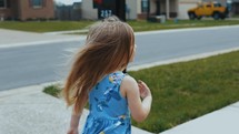 child walking on a sidewalk 