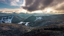 Hyper lapse of fast clouds above a winter forest in a sunny mountains landscape.