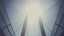 Sun shining over bridge cables.