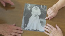 a couple looking at an old wedding photograph 