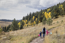 mother and kids walking on a mountain trail 