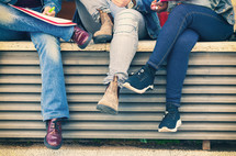 Legs of students sitting on a bench. Study concept.