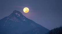 Full moon fall down over forest mountains Time lapse
