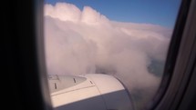 The view from the airplane window. Flying above the blue sky with moving clouds. Traveling on airplane. 