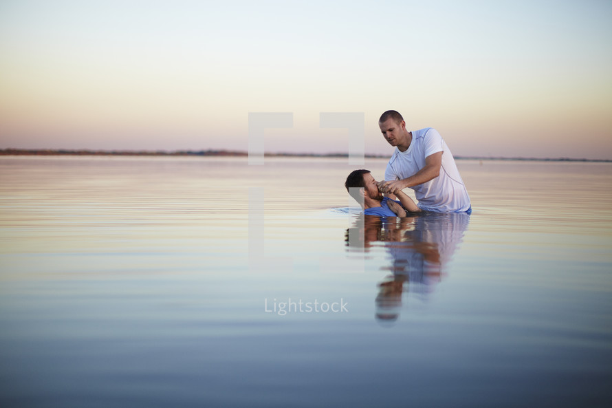 Man being baptized in a lake