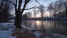 Winter sunrise on river bank
