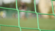 soccer game through a soccer net 