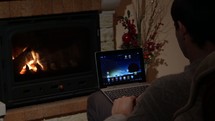 a man using a laptop sitting in front of a tablet 