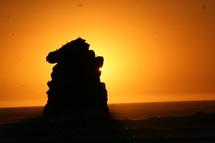 glowing sun behind a rock formation