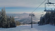 Empty chairlift in closed ski resort due to coronavirus in beautiful sunny winter season in alpine mountains
