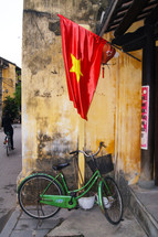 A bike sitting under a Vietnamese flag