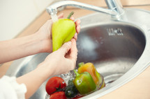 a woman washing vegetables 