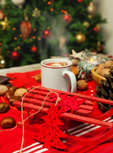 Cup of hot tea on Christmas table with behind Christmas tree