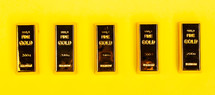 Bars of gold bullion on yellow background. Financial concept.