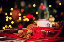 Cup of hot tea on Christmas table with behind christmas tree