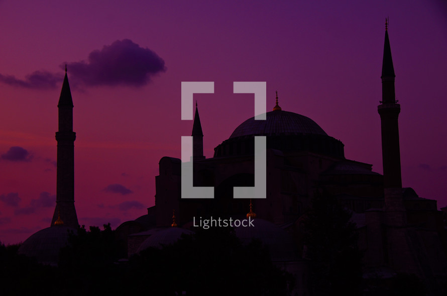 silhouette of a mosque under a purple sky
