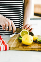 slicing a lemon and lime in a kitchen 