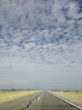 Cloudy sky over a two-lane road.