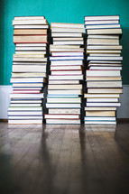 stacked books on a wood floor 
